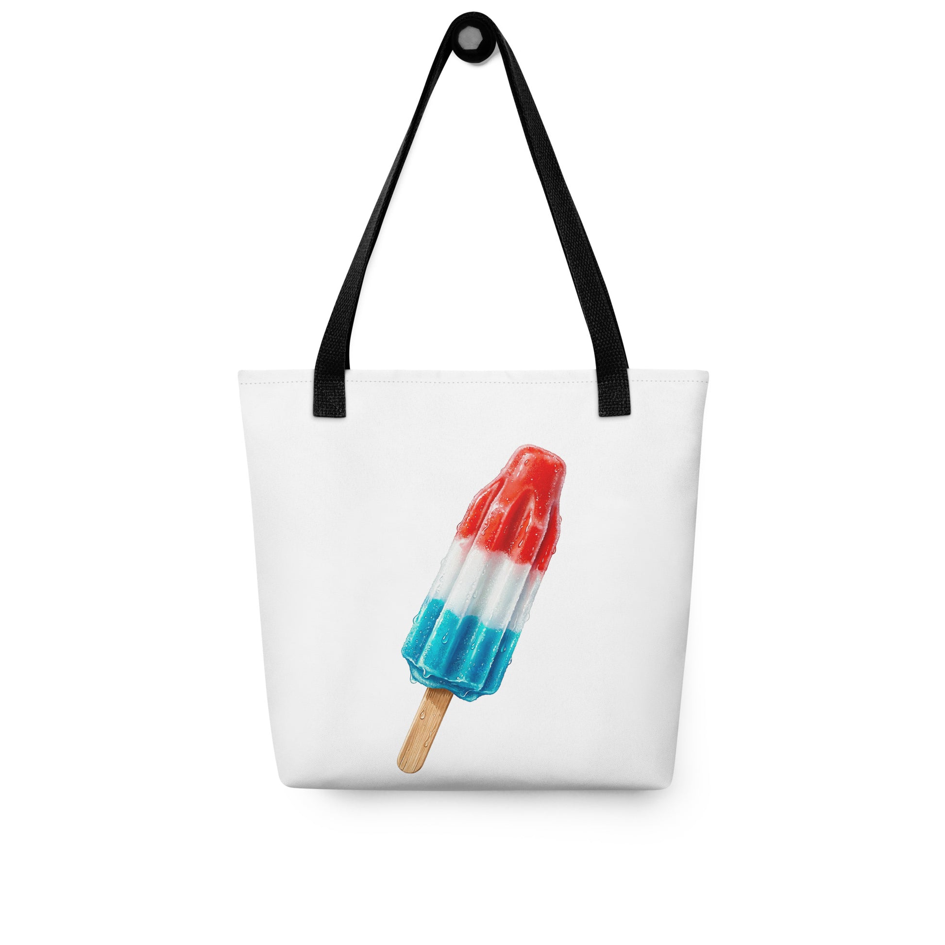 A white tote bag with black shoulder straps, a fun summer graphic of a red, white, and blue popsicle